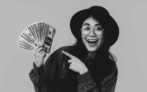 A black-and-white image of a woman holding money, symbolizing how CodexCon’s affordable web development helps small businesses save and grow.